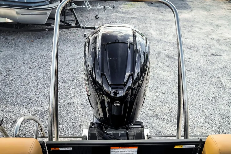Slide: The Image of 2025 SunCatcher Fusion 324RC boat engine, sleek black design, parked on gravel. - 34