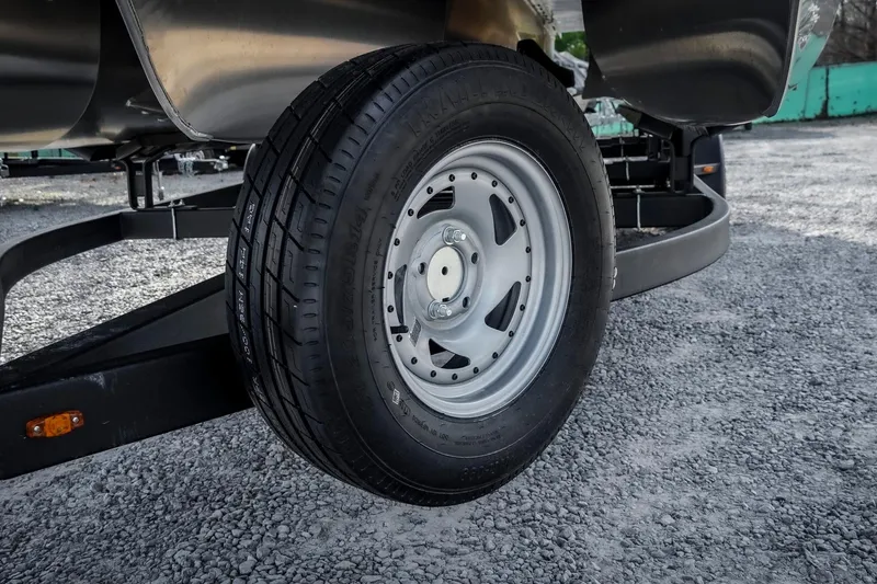 Slide: The Image of 2025 SunCatcher Fusion 324RC trailer wheel on gravel surface. - 35