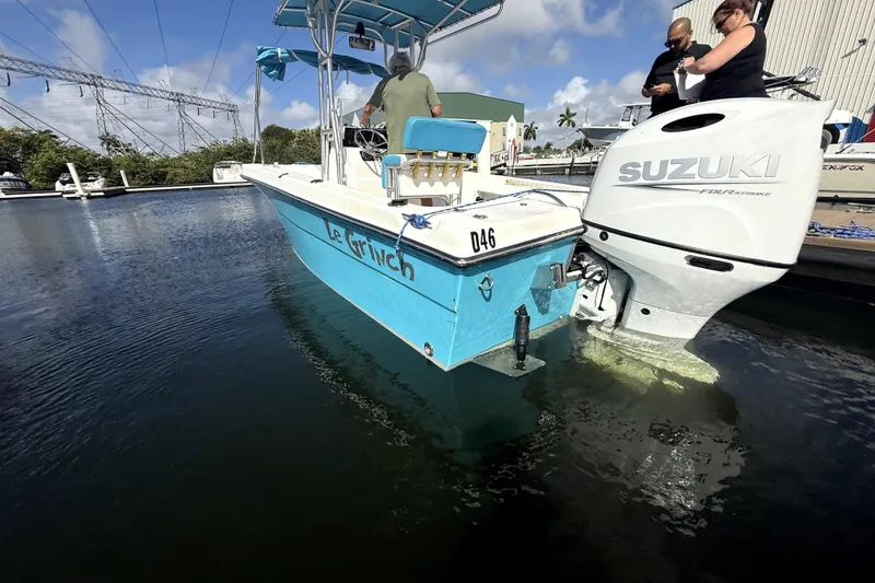 Slide: The Image of 2005 Angler 204 Center Console boat on trailer beside a house, under a cloudy sky. - 2