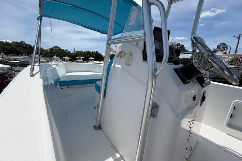 Slide: The Image of 2005 Angler 204CC boat interior with blue canopy and steering console. - 30
