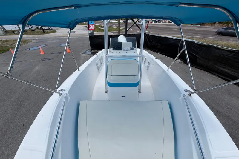 Slide: The Image of 2005 Angler 204CC boat with blue canopy, parked on pavement near traffic cones. - 39