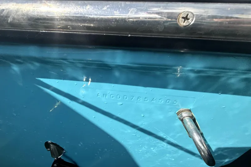 Slide: The Image of 2005 Angler 204 Center Console boat on trailer, parked beside a house. - 4