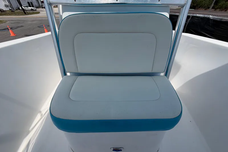 Slide: The Image of 2005 Angler 204CC boat seat with blue trim, outdoor setting. - 41