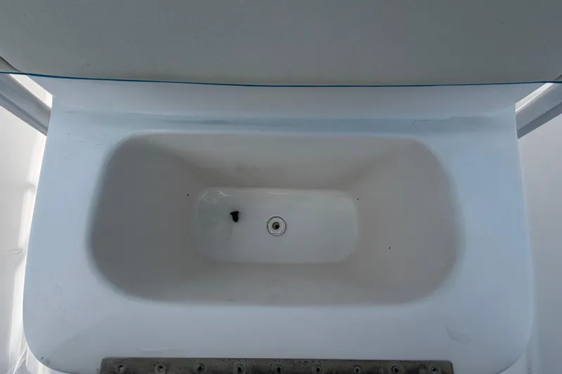 Slide: The Image of Livewell compartment in a 2005 Angler 204CC boat, featuring a clean, white interior. - 42