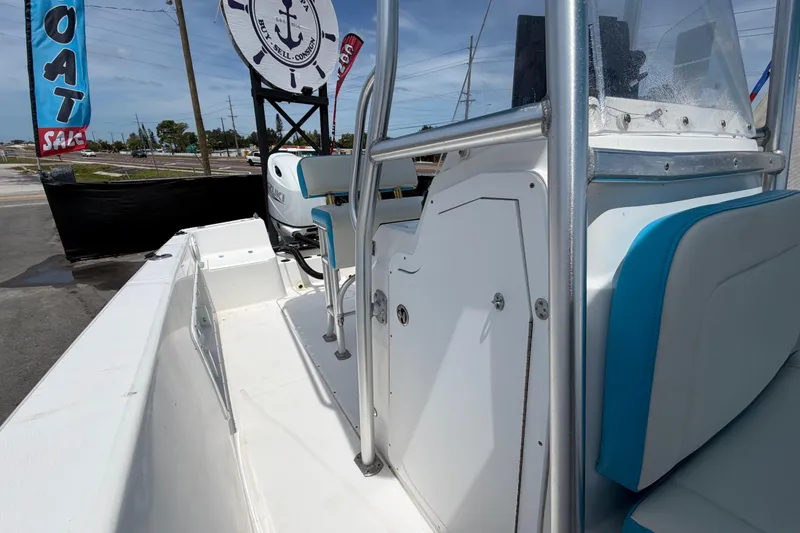 Slide: The Image of 2005 Angler 204CC boat interior with blue and white seating, displayed at a sale event. - 43