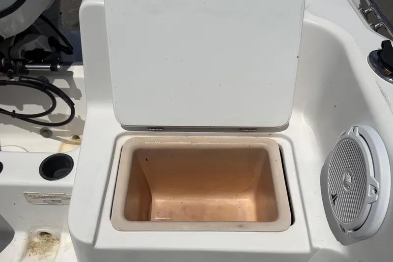 Slide: The Image of Open storage compartment on 2005 Angler 204CC boat, featuring a white interior and speaker. - 55