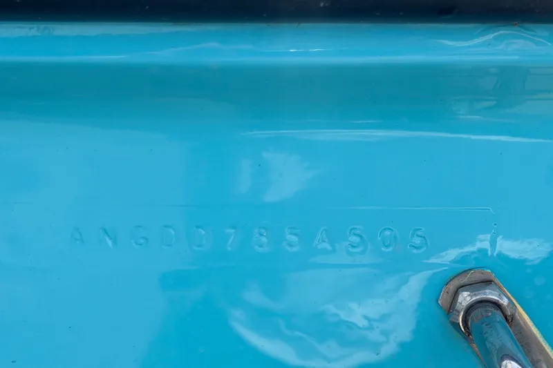 Slide: The Image of Close-up of a 2005 Angler 204CC boat hull identification number on a blue surface. - 61
