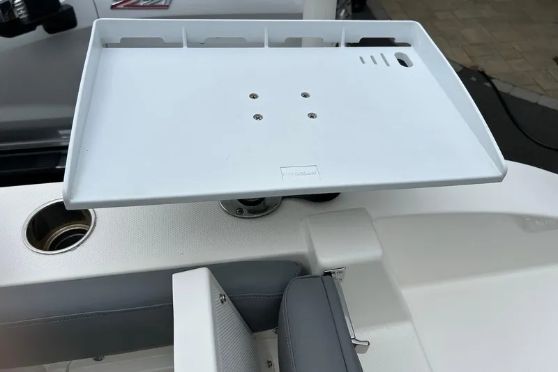 Slide: The Image of 2023 NauticStar 24 Legacy boat accessory tray and cup holder detail. - 11