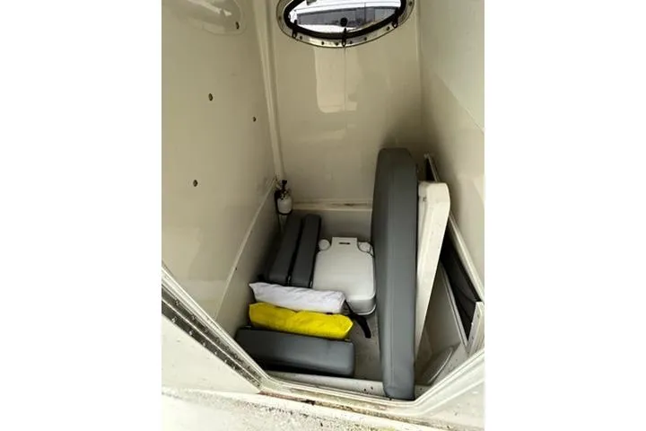Slide: The Image of 2023 NauticStar 24 Legacy boat interior with seating and storage area. - 13