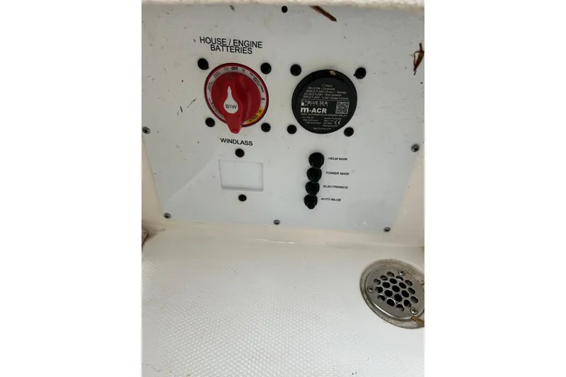 Slide: The Image of Control panel of 2023 NauticStar 24 Legacy boat with battery switches and drain. - 15