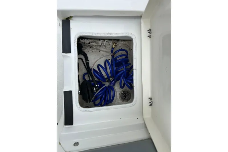 Slide: The Image of Storage compartment with blue hose in 2023 NauticStar 24 Legacy boat. - 16
