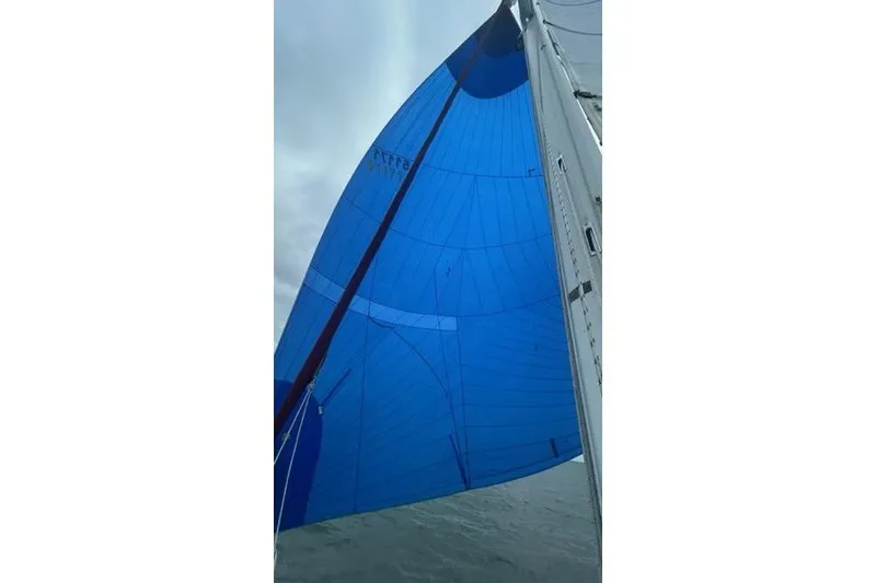 Slide: The Image of Blue sail of a 1998 Catalina 42 yacht against a cloudy sky. - 13