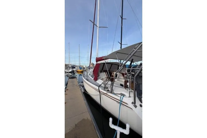 Slide: The Image of 1998 Catalina 42 sailboat docked at marina, featuring sleek design and maroon accents. - 15