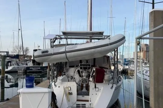 Slide: The Image of 1998 Catalina 42 sailboat docked at marina with dinghy on deck. - 16