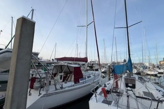 Slide: The Image of 1998 Catalina 42 sailboat docked among other boats in a marina. - 18