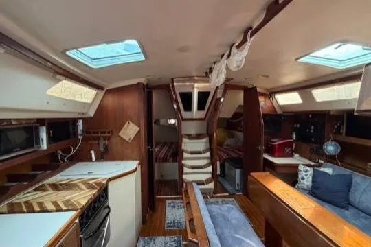 Slide: The Image of Interior of a 1998 Catalina 42 sailboat with cozy seating and kitchen area. - 21