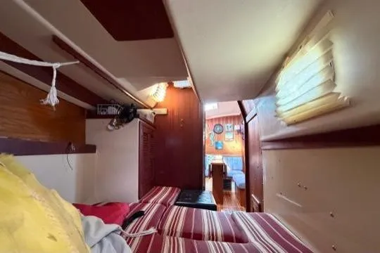 Slide: The Image of Cozy interior of a 1998 Catalina 42 sailboat with striped bedding and wooden accents. - 24