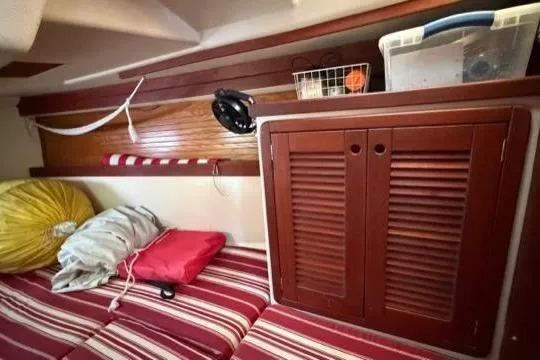 Slide: The Image of Cozy interior of 1998 Catalina 42 sailboat with striped cushions and wooden cabinetry. - 25