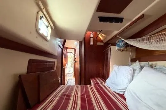 Slide: The Image of Cozy interior cabin of a 1998 Catalina 42 sailboat with striped bedding. - 26