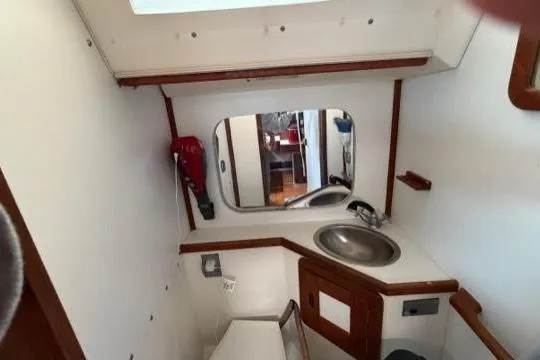 Slide: The Image of 1998 Catalina 42 yacht bathroom with sink, mirror, and fire extinguisher. - 27