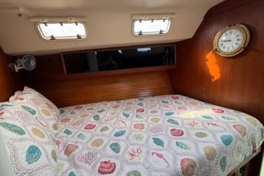 Slide: The Image of Cozy cabin interior of 1998 Catalina 42 sailboat with colorful bedding and wall clock. - 28