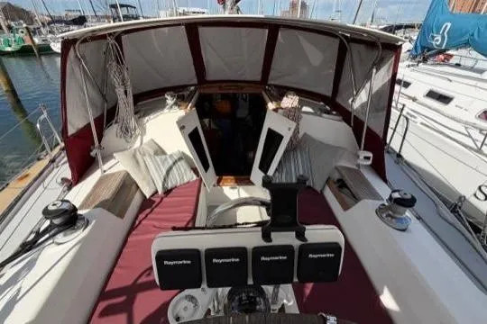 Slide: The Image of 1998 Catalina 42 sailboat cockpit with maroon cushions and covered helm, docked at marina. - 33