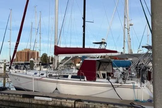 Slide: The Image of 1998 Catalina 42 sailboat docked at marina with red sail cover. - 4