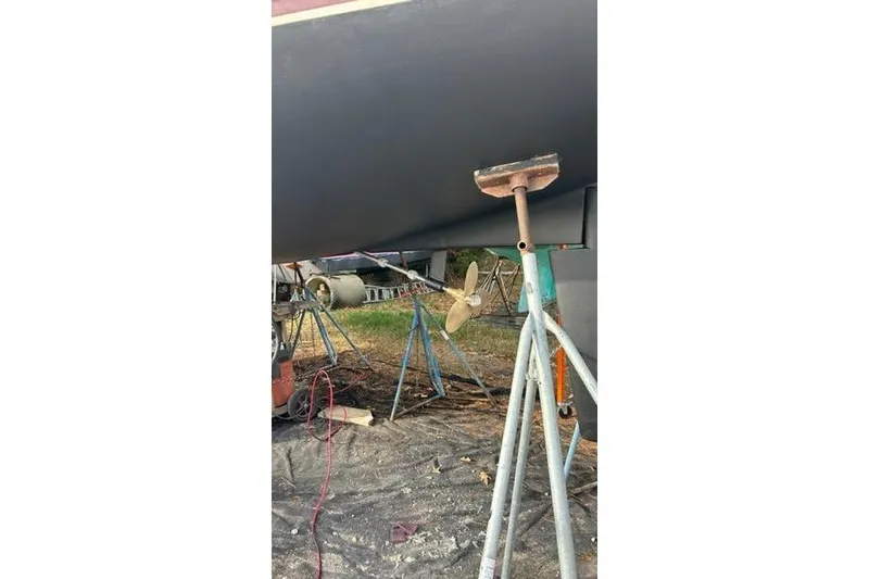 Slide: The Image of 1998 Catalina 42 sailboat hull on stands, with visible propeller and maintenance equipment. - 7