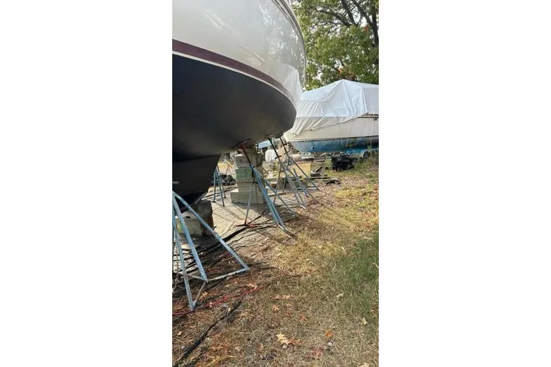 Slide: The Image of 1998 Catalina 42 sailboat on stands, stored outdoors, with covered boat nearby. - 8