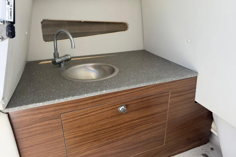 Slide: The Image of 2020 Glastron GTD 240 boat interior with compact sink and wooden cabinet. - 10