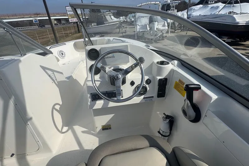 Slide: The Image of 2021 Key West 203 DFS boat cockpit with steering wheel and controls. - 11