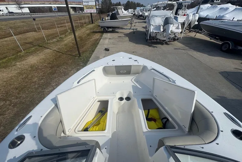 Slide: The Image of 2021 Key West 203 DFS boat with open storage compartments, parked outdoors. - 16