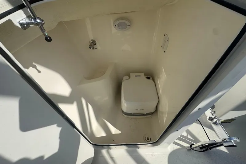 Slide: The Image of 2021 Key West 203 DFS boat interior with portable toilet in enclosed compartment. - 19