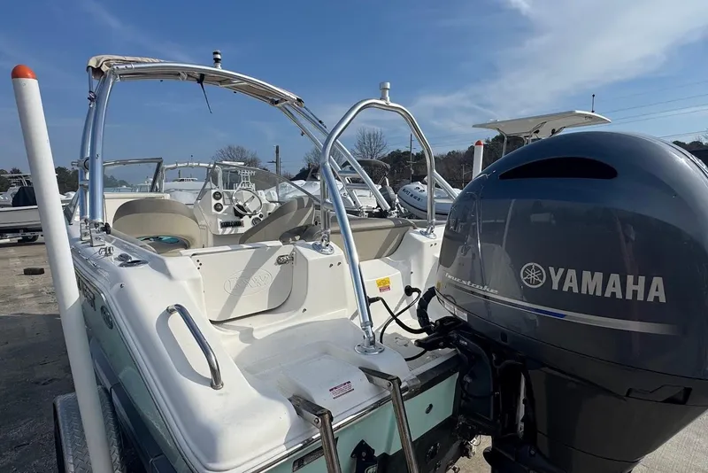 Slide: The Image of 2021 Key West 203 DFS boat with Yamaha engine, parked outdoors under clear sky. - 6