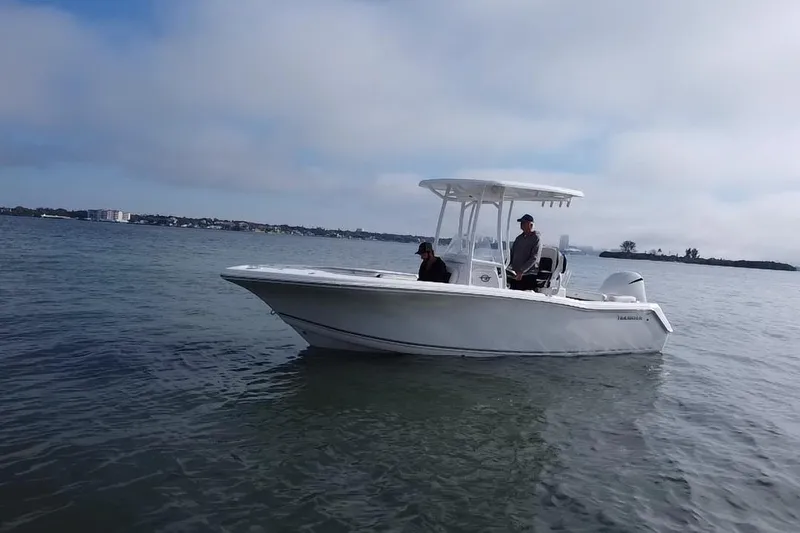 Slide: The Image of 2024 Tidewater 220 LXF boat on calm water with two people onboard. - 18