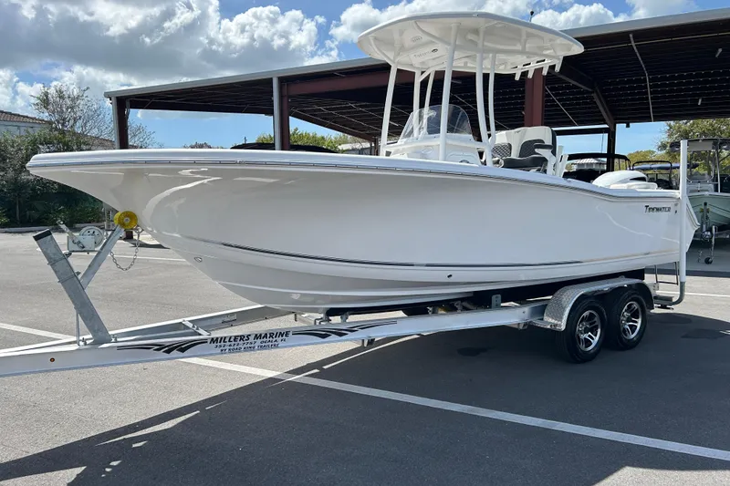 Slide: The Image of 2024 Tidewater 220 LXF boat on trailer under blue sky, parked at marina. - 5