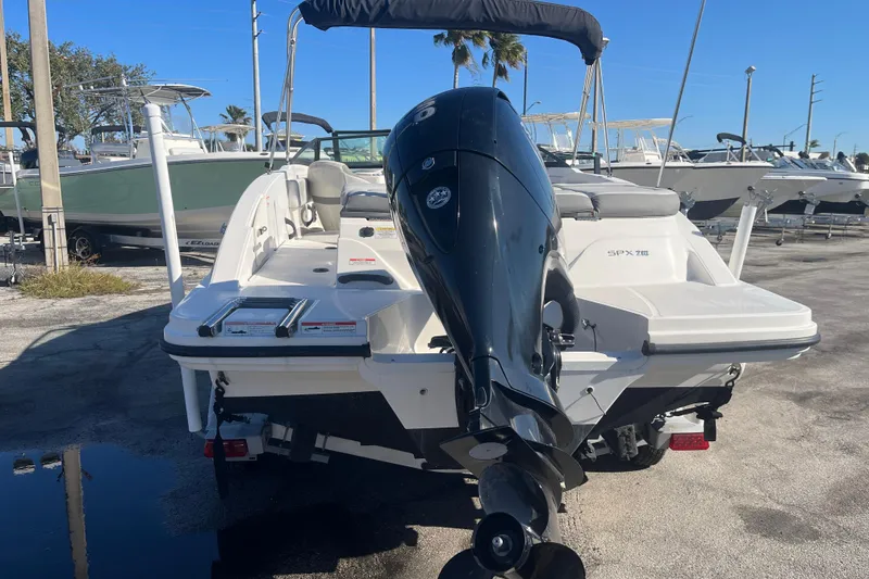 Slide: The Image of 2020 Sea Ray SPX 210 boat with outboard motor, parked in a marina. - 5