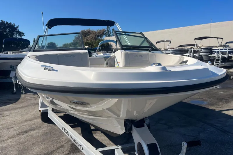 Slide: The Image of 2020 Sea Ray SPX 210 boat on trailer, parked outdoors under clear blue sky. - 6