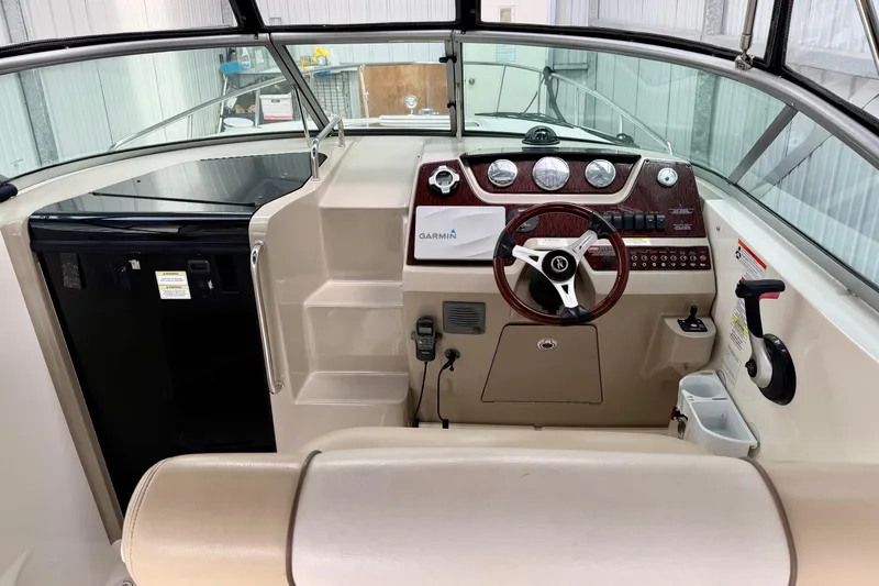 Slide: The Image of 2012 Sea Ray Sundancer 280 helm with Garmin navigation, wood-trimmed steering, and control panel. - 17
