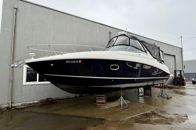 Slide: The Image of 2012 Sea Ray Sundancer 280 boat on stands outside a warehouse. - 2