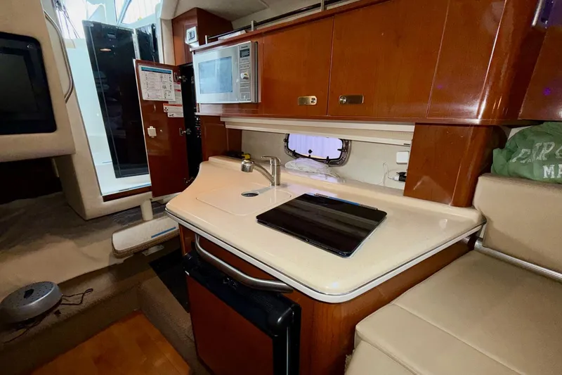 Slide: The Image of Interior of 2012 Sea Ray Sundancer 280 yacht, featuring a compact kitchen area. - 30