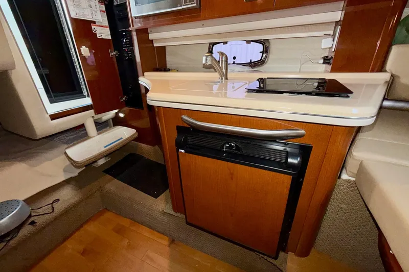 Slide: The Image of Interior of 2012 Sea Ray Sundancer 280 yacht with kitchenette and wood cabinetry. - 31