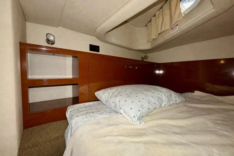 Slide: The Image of Cozy cabin interior of 2012 Sea Ray Sundancer 280 with bed and wooden shelving. - 36