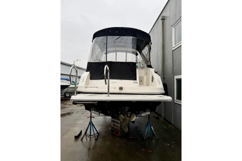 Slide: The Image of 2012 Sea Ray Sundancer 280 boat on stands, rear view, in a marina setting. - 4