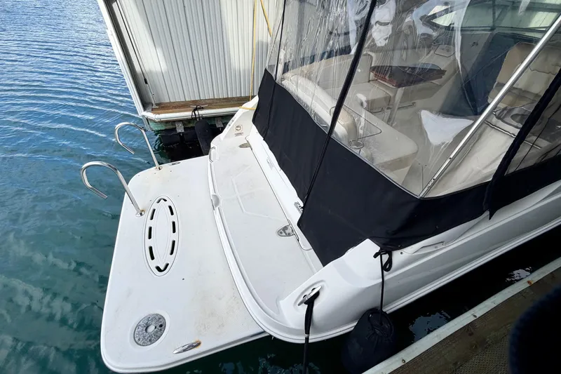 Slide: The Image of 2012 Sea Ray Sundancer 280 docked, featuring swim platform and clear canopy. - 7