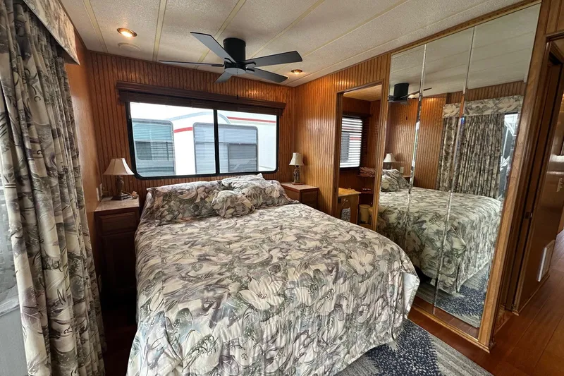 Slide: The Image of Bedroom interior of 1993 Sumerset 14x65 houseboat with floral bedding and mirrored closet. - 11