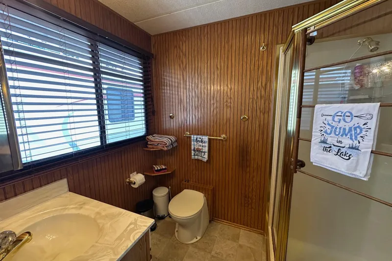 Slide: The Image of Bathroom in 1993 Sumerset 14x65 houseboat with wood paneling and decorative towels. - 13