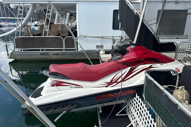 Slide: The Image of Red Sea-Doo jet ski docked beside a 1993 Sumerset 14x65 houseboat. - 14