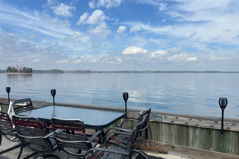 Slide: The Image of Outdoor dining set overlooking serene lake with cloudy sky, Sumerset 14x65, 1993. - 15