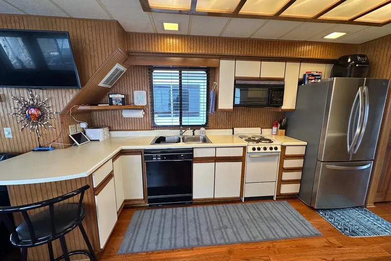 Slide: The Image of Kitchen interior of a 1993 Sumerset 14x65 houseboat with modern appliances. - 4
